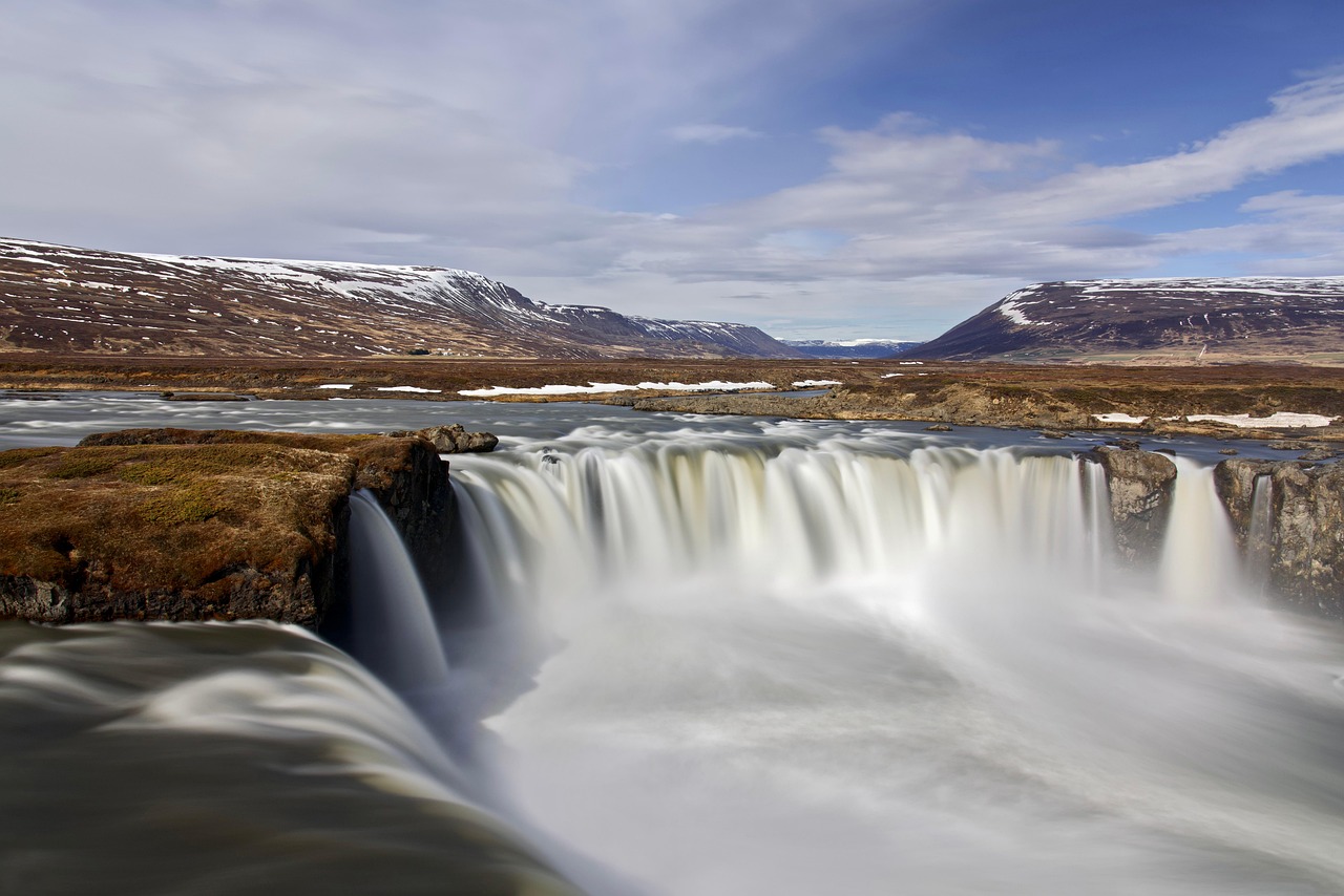 powerful waterfall cascading over black lava rocks in south iceland under soft sky