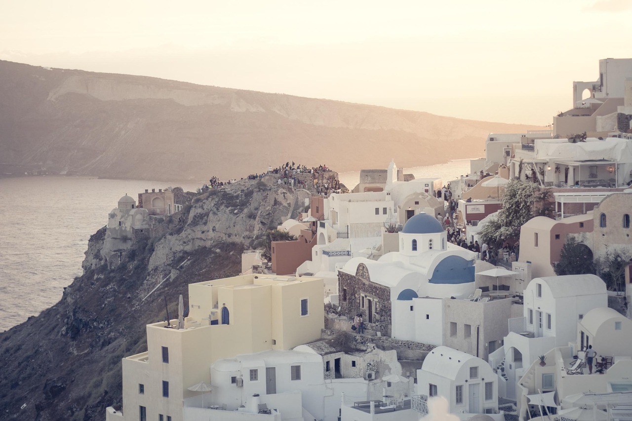 Santorini sunset over white-washed buildings and calm Aegean water