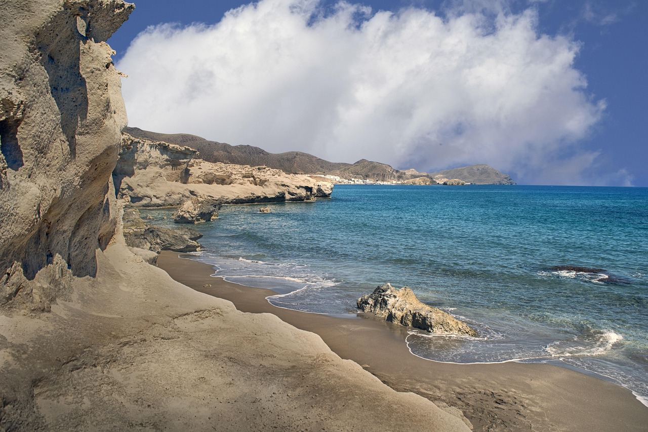 Red volcanic cliffs and turquoise water at Grafsi Beach, Milos