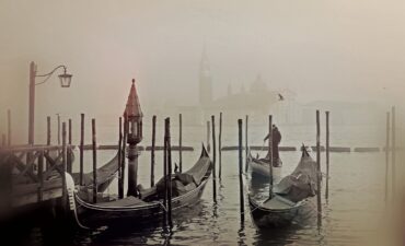 Things to do in venice - Gondola gliding through a narrow canal in the heart of Venice, Italy