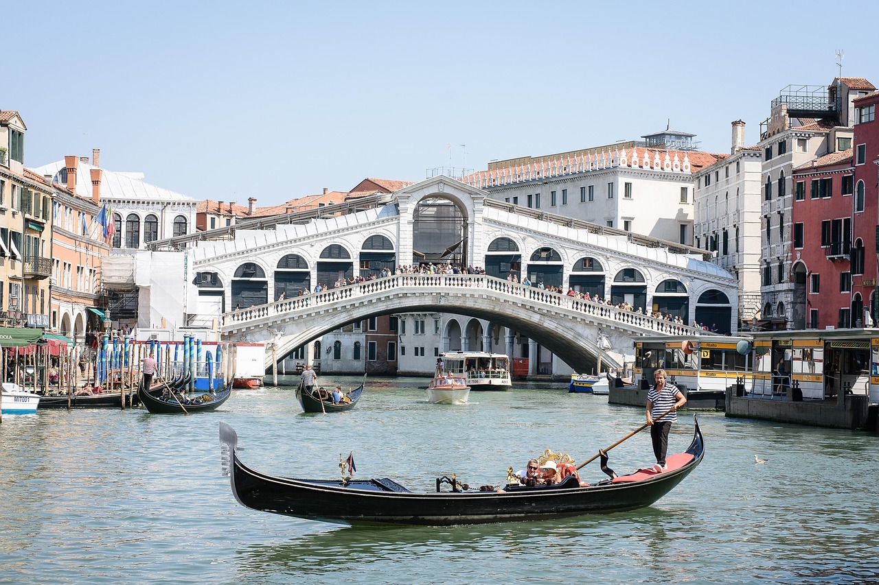 Bustling market stalls under the arches of Rialto Bridge in Venice, Italy